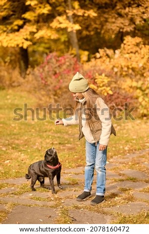 A cute girl playing with her dog in the park