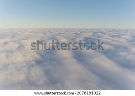 Aerial view of the clouds from the cockpit of a private jet. Foggy sky. Sky background with sun