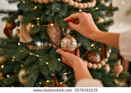 Merry Christmas and Happy New Year! Women's hands decorate the Christmas tree with balls and toys. Royalty-Free Stock Photo #2078183239