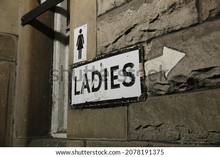 Ladies Written With a Sign and an Arrow on Limestone Building Pointing to the Public Toilets  in Edinburgh Scotland
