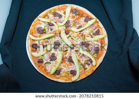 Pizza on a black background. Top view of the pizza. A dish for a restaurant and cafe. Pizza made from different products.