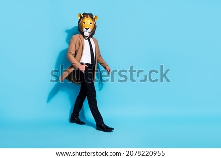 Full length profile side photo of incognito guy walk mardi-gras fantasy occasion isolated over blue color background