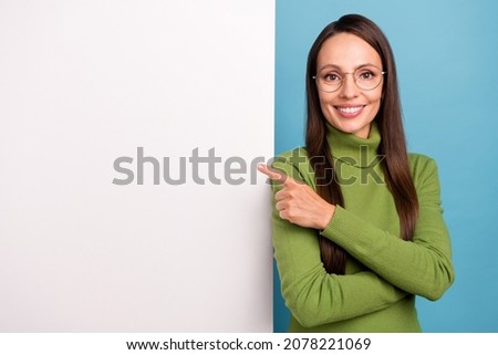 Photo of mature hr lady index empty space wear spectacles green sweater isolated on blue color background