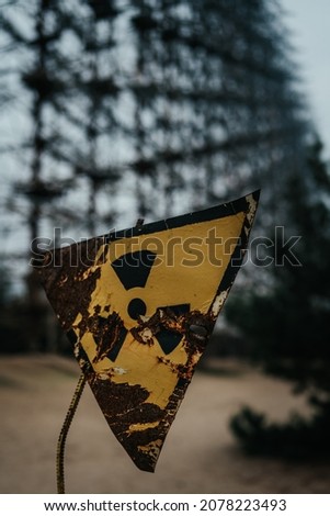 A vertical shot of a damaged yellow danger sign outdoors