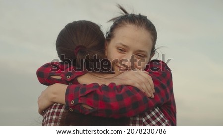 girl hugs her friend outdoors nature, happy family, daughter smiles on mom's shoulder, trust in relationships of people, kindness and support with good smile emotions, sincere tenderness day gratitude Royalty-Free Stock Photo #2078230786