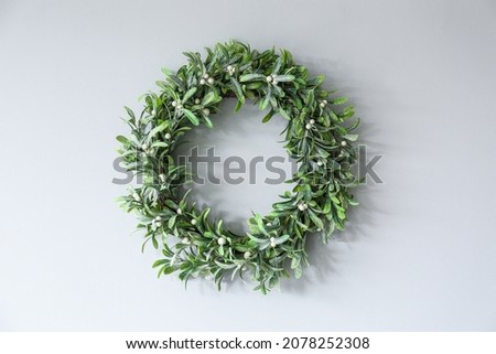 Beautiful mistletoe wreath hanging light on wall in room