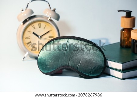 Sleeping mask with books on color background