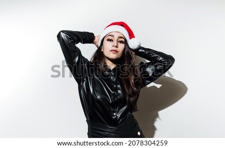 Portrait of latin woman with Santa's hat for christmas, pictured in a studio on white background 

