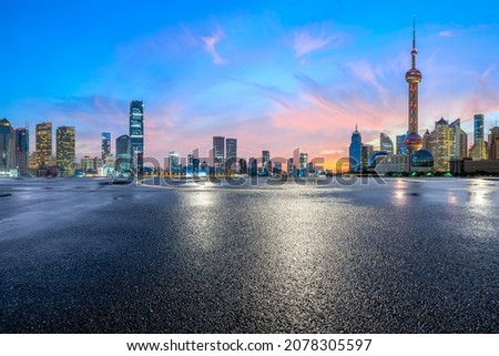 Empty asphalt road and modern city skyline with buildings in Shanghai at sunrise
