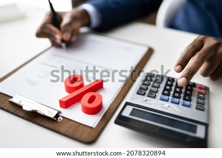 Red Percentage Symbol In Front Of Businessperson Calculating Invoice