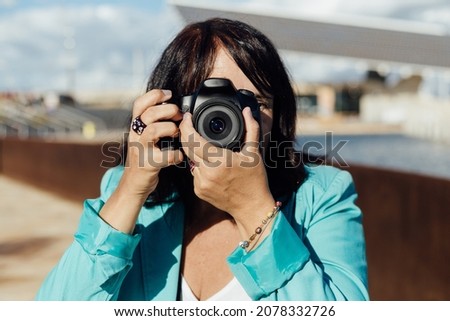 Woman taking a photo with her digital camera, Professional photographer shooting a picture.