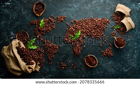 Set of coffee beans and ground coffee in the shape of a world map. Top view. On a dark background.