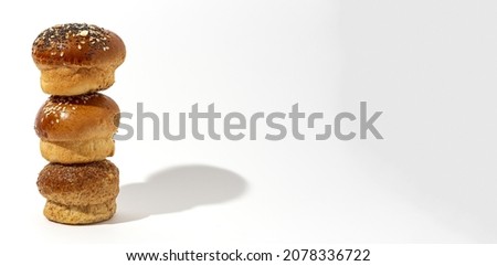 Assorted round homemade brioche buns with seeds on a white background with high contrast light. Isolated
