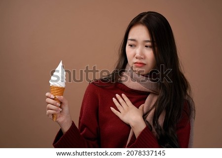 Asian woman with vanilla ice cream cone , Winter outfit wear red sleeves and pink scarf, Isolated brown  background