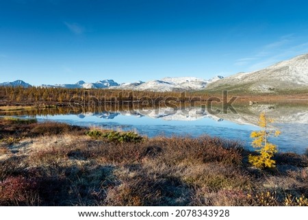 Russia. Magadan Region. A beautiful forest lake against the backdrop of the Big Anngachak mountain range. Autumn in the vicinity of Lake Jack London. Royalty-Free Stock Photo #2078343928
