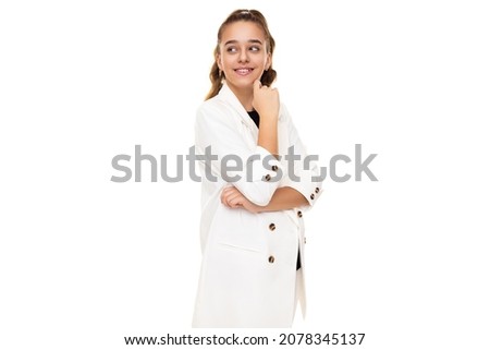 Photo of beautiful cute adorable positive smiling brunette teenage girl with ponytail in stylish white jacket and white pants isolated on white background with copy space for text