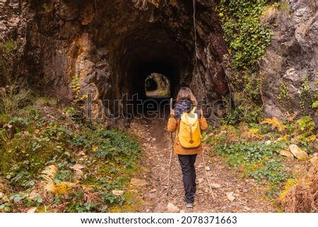 A young woman on the path of tunnels of old mines in Mount Erlaitz in the town of Irun, Gipuzkoa. Basque Country