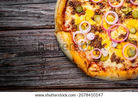 Pizza with Mozzarella cheese, Bolognese sauce, minced meat and vegetables. Italian pizza on wooden background.