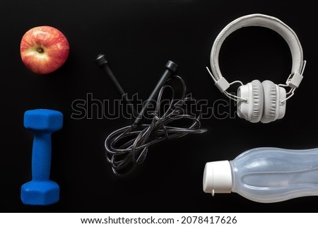 Flat lay composition with sports equipment on black.