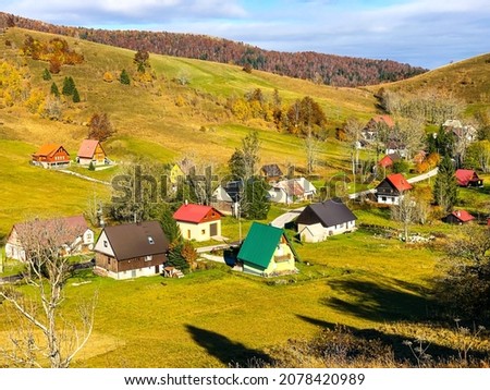 A beautiful rural landscape with house buildings and autumn colored trees