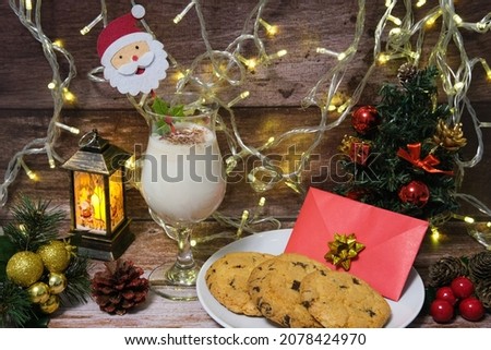 Milk with Christmas cookies for santa claus on a wooden table, selective focus. 