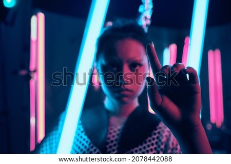 Futuristic portrait of asian teenager in neon light with sword like lamps pointing finger, selective focus. She is seriour, daring, cyberpunk fashionable girl, wearing net clothes, white eyebrows