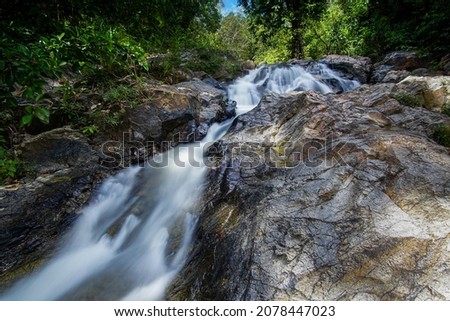 Tropical landscape. Beautiful hidden waterfall in rainforest. Adventure and travel concept. Nature background. Slow shutter speed, motion photography in Kg Sg Sok Kuala Krai Kelantan Malaysia
