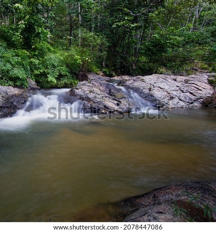 Tropical landscape. Beautiful hidden waterfall in rainforest. Adventure and travel concept. Nature background. Slow shutter speed, motion photography in Kg Sg Sok Kuala Krai Kelantan Malaysia