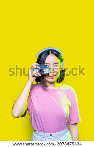 Young asiatic woman isolated background taking photo using retro vintage camera photographing collecting memories