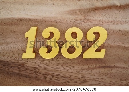 Golden Arabic numerals 1382 on a dark brown to white wood grain background.