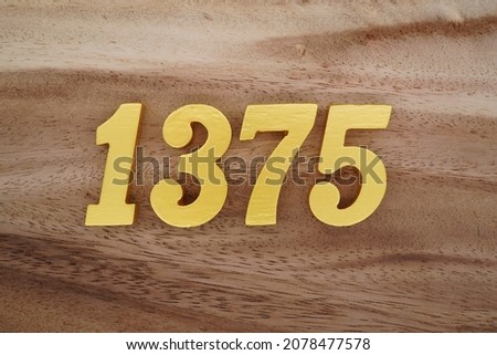 Golden Arabic numerals 1375 on a dark brown to white wood grain background.