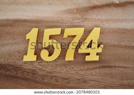 Golden Arabic numerals 1574 on a dark brown to white wood grain background.