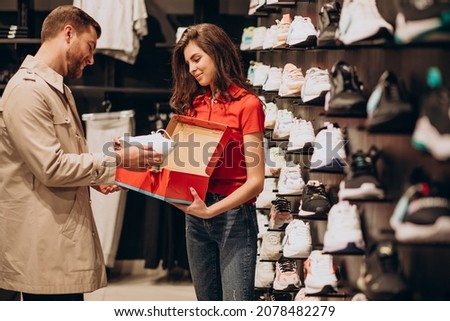 Young man choosing sneakers at sportswear shop Royalty-Free Stock Photo #2078482279
