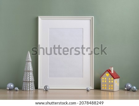 Christmas composition of Christmas decorations, pine branches, House lantern and a white mock up poster frame for presentation of works and text. Template.