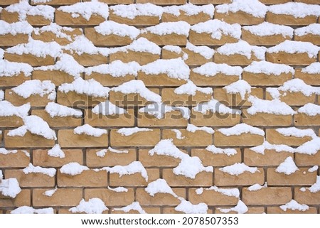 Snow on decorative beige brick