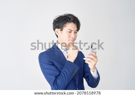 Asian businessman thinking with the smartphone on white background