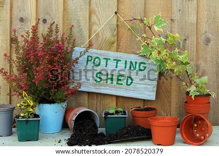 Potting Shed Written On A Wooden Board Hanging On Wood Panelling.