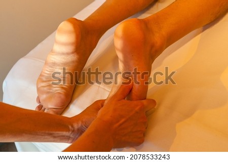 Foot sole massage, masseuse hands massaging man's foot