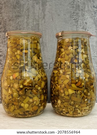 Chili pepper preserved in huge jars. Homemade spicy peppers slices pickles food.