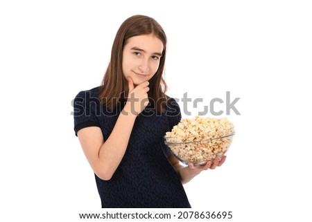 Portrait of a beautiful girl holding a bowl of popcorn standing on white. High resolution photo.