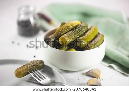 Pickled gherkins. Salted Cucumbers on a white concrete background, horizontal