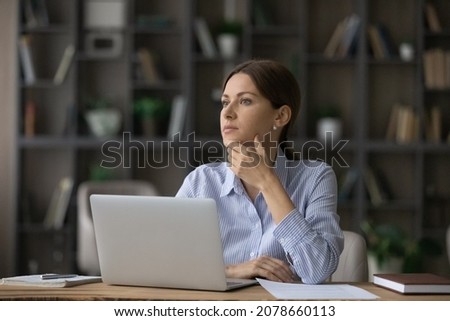 Attractive woman deep in thoughts sit at workplace near laptop. Pensive business lady thinking over business task looks into distance, take break distracted consider issue. Workflow, challenge concept Royalty-Free Stock Photo #2078660113