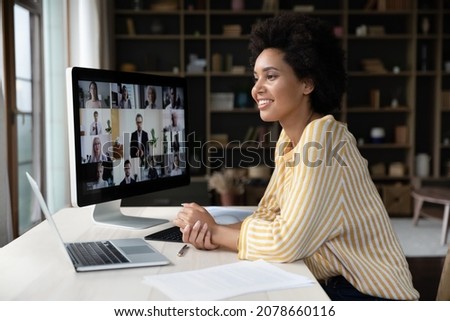 Happy African American remote employee talking on video conference call to colleagues, sitting at computer monitor, speaking to audience, attending virtual business meeting, negotiations, seminar Royalty-Free Stock Photo #2078660116