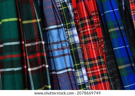 An assortment of colourful Scottish tartan kilts. Royalty-Free Stock Photo #2078669749