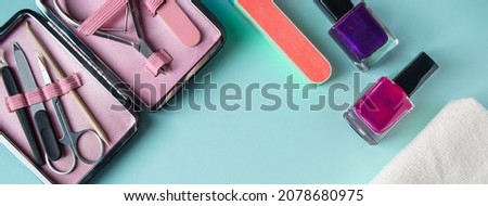 Workplace in a nail salon. A set of tools for hand care on a blue background. Place for text, banner format