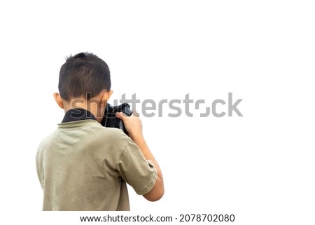 Asian boy holding a digital camera or DSLR to taking a photo isolated on white background.