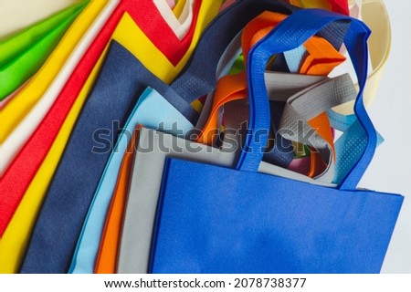 colorful non-woven fabric tote bag. a collection made of non-woven fabrics of various colors. pile of textured and porous polypropylene material. partially sighted image Royalty-Free Stock Photo #2078738377