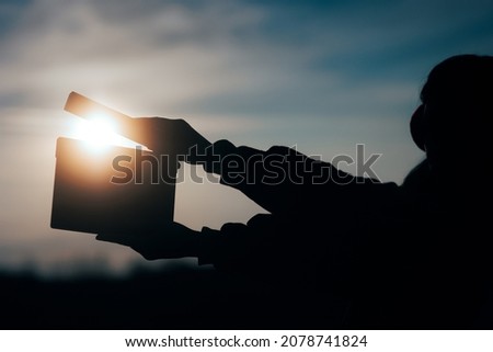 
Silhouette of Hands Holding a Film Slate in the Sunset. Film production for motion picture rolling on outdoors set in nature
 Royalty-Free Stock Photo #2078741824
