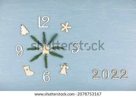 Christmas layout, clock made of wooden numerals with hands of spruce branches, 2022
