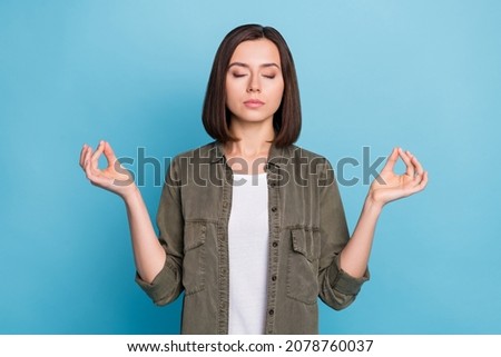 Photo of focused lady meditate catch zen symbol wear khaki grey outfit isolated over blue color background